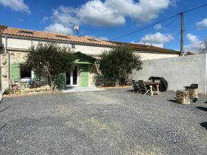 a building with a green door and a table at Maison de charme au cœur des vignes et Gironde in Gauriac
