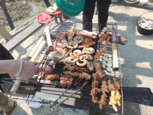 ein Grill mit vielen verschiedenen Arten von Speisen darauf in der Unterkunft H'mong Eco House in Lào Cai