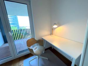 a desk and a chair in a room with a window at Luxuriöses 130qm Apartment mit Balkon im Zentrum,Parkplatz in Heilbronn