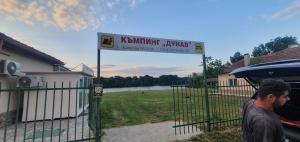 a man standing in front of a gate with a sign at Хотел Дунав Свищов in Svishtov