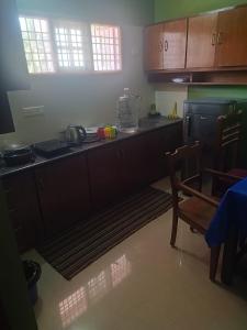 a kitchen with wooden cabinets and a table and a table and chairs at La Maison Renald in Pondicherry