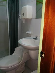 y baño con aseo y lavamanos. en Apartamento Top House, en Puerto Baquerizo Moreno