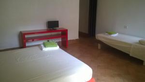 a room with two beds and a desk with a television at Colonna Home in Florence