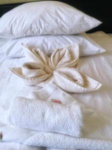 a white bed with towels and a flower on it at Apartament Anita in Vulcan