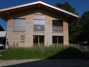 ein Gebäude mit einem Zaun davor in der Unterkunft Stylische Fewo in Bestlage in neugebautem Holzhaus mit Oberstaufen Plus in Oberstaufen
