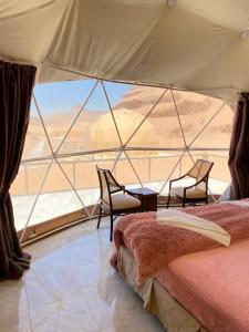 una camera da letto con vista sul deserto da una tenda. di Rum Elizabeth camp a Wadi Rum