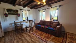 a living room with a couch and a table at Casa bunicilor din Oncești in Onceşti