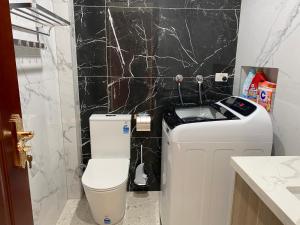 a bathroom with a toilet and a black marble wall at Penshurst Guest House in Sydney