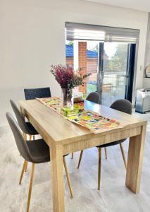 a dining room table with a vase of flowers on it at Penshurst Guest House in Sydney