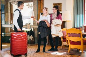 um grupo de três pessoas numa sala com bagagem em Hotel Sonnalm em Bad Kleinkirchheim