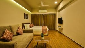 a living room with a couch and a bed at The Weekend Address in Surat