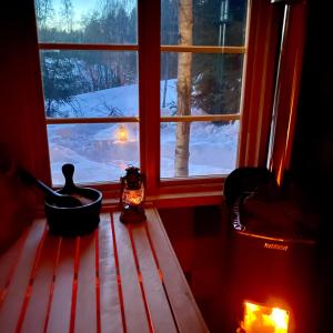 una ventana con vistas a un patio cubierto de nieve en Glamping Höga Kusten en Undrom