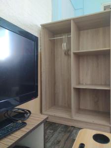 una sala de estar con TV y armarios de madera. en cozy place in texas, en Pemulutan-hilir