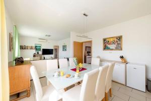 a kitchen and dining room with a white table and chairs at Apartman JAM in Solin