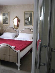 a bedroom with a bed with a red blanket at Holly Tree B&B in Bromyard
