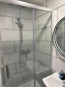 a shower with a glass door next to a sink at Charming Studio Apartment in London in London