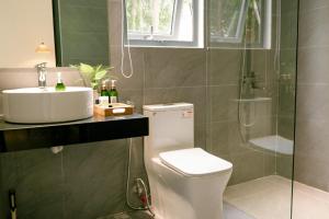 La salle de bains est pourvue de toilettes, d'un lavabo et d'une douche. dans l'établissement ChocoHouse, à Hue