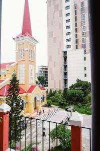 a yellow church with a steeple in a city at ChocoHouse in Hue