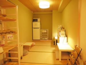 東京にあるbnb+ Akihabara (Female Only)の冷蔵庫、テーブル、椅子が備わる客室です。