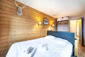 1 dormitorio con 1 cama grande y toallas. en Le Croc Blanc en Morzine