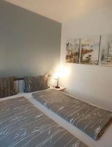 een slaapkamer met een bed en een tafel met een lamp bij Apartament Villa Natura II in Szczytno