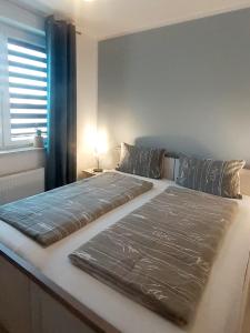 a large bed in a bedroom with a window at Apartament Villa Natura II in Szczytno