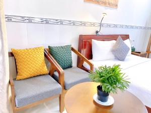 um quarto com uma cama, 2 cadeiras e uma mesa em Have Fun Phú Quốc em Phu Quoc