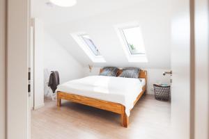 ein Schlafzimmer mit einem Bett und zwei Oberlichtern in der Unterkunft Casa Ueberall in Fehmarn