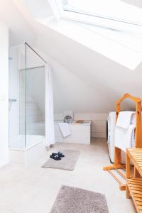 biały pokój z prysznicem i łóżkiem w obiekcie Casa Ueberall w mieście Fehmarn