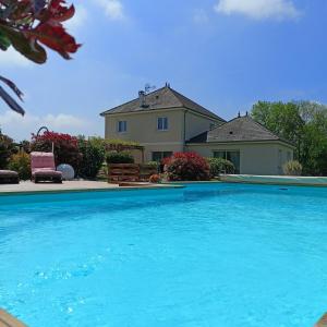 una gran piscina azul frente a una casa en Le paon de bois, en Saint-Mards-en-Othe