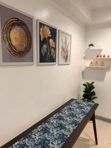 Charm’s Place في اولونجابو: غرفة مع طاولة وبعض الصور على الحائط