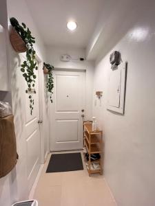 a hallway with a white door and a black rug at Charm’s Place in Olongapo