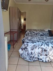 a bedroom with a bed and a tiled floor at Forget me Not Lydenburg in Lydenburg