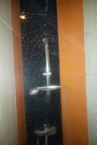 y baño con ducha y pared de azulejos. en OYO Life 90646 Villa Karsinem Pasuruan en Pasuruan