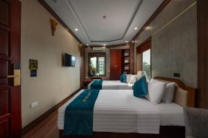 1 dormitorio con 2 camas y almohadas azules y blancas en Hanoi Airport Hotel - Convenient & Friendly, en Noi Bai
