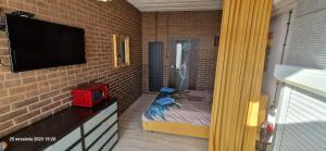 een kleine slaapkamer met een bed en een televisie bij WILLA VASCO BOSMAN in Rewa