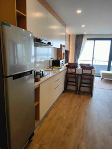 uma cozinha com um frigorífico de aço inoxidável e uma mesa em 902 Hareta Serviced Apartment em Phnom Penh