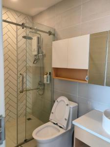 uma casa de banho com um WC e uma cabina de duche em vidro. em 902 Hareta Serviced Apartment em Phnom Penh