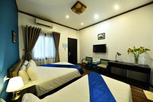 ein Hotelzimmer mit 2 Betten und einem Schreibtisch in der Unterkunft Hanoi Starlight Boutique Hotel in Hanoi