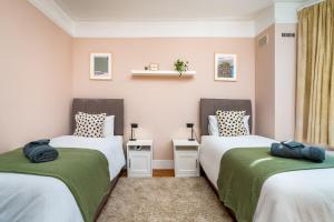 una camera con due letti con lenzuola verdi e bianche di Homely and Stylish Apartment with a garden in East Finchley a Londra