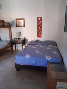 a bedroom with a bed with a blue comforter at Casa Hostal Arena de Mar in Necoclí