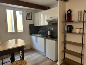 a kitchen with white cabinets and a counter top at COCON CENTRAL - Cathédrale & Castillet - Parking Gratuit - Wifi in Perpignan