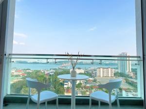 tavolo e sedie in una stanza con una grande finestra di Paragon Suite Homestay by Antlerzone a Johor Bahru