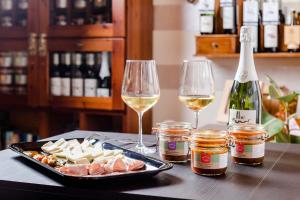 a table with two glasses of wine and a plate of food at Agriturismo dei Grippi in Sona