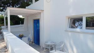 マルティナ・フランカにあるCasa Vacanze Villa Grecaの白い家(青いドア、テーブル、椅子付)