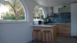 cocina con encimera con taburetes y ventana en Casa Vacanze Villa Greca, en Martina Franca