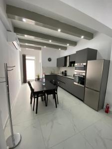 a kitchen with a table and a kitchen with a refrigerator at Seaside Apartment in Gzira in Il-Gżira
