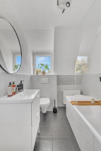 a white bathroom with a tub and a toilet and a sink at Superb - Schlossblick - Zentral - Smart TV in Wernigerode