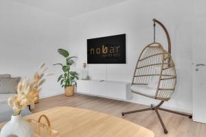 a living room with a rattan chair and a tv at Superb - Schlossblick - Zentral - Smart TV in Wernigerode