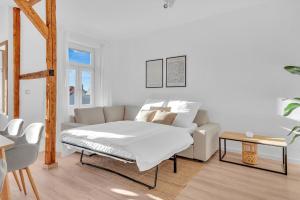 a white living room with a bed and a couch at Superb - Schlossblick - Zentral - Smart TV in Wernigerode